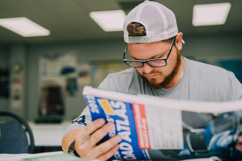 TDI student looks at a road atlas in the classroom.